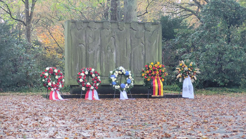 Gedenktafel auf dem Osterholzer Friedhof mit Kränzen