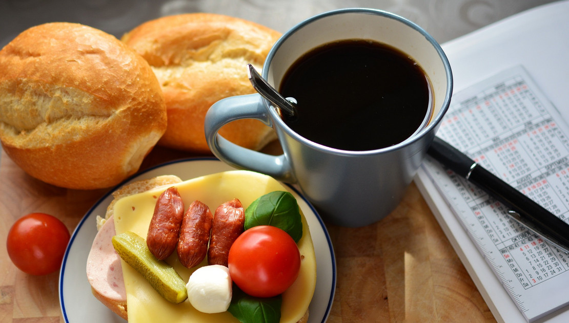 Brötchen, Kaffeetasse und Terminkalender