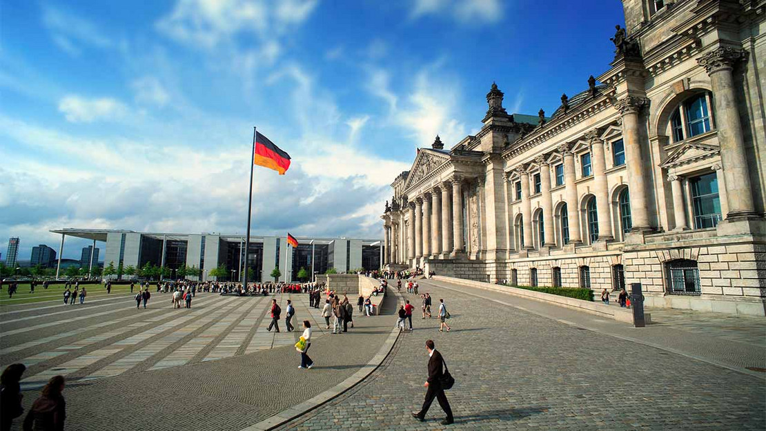 Eingang des Reichstags, im Hintergrund das Kanzleramt bei sonnigem Wetter. 
