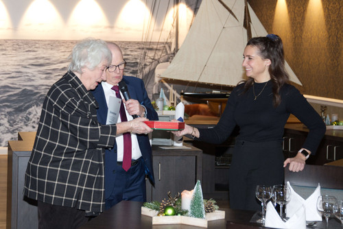 Helga Harms wird von Joachim Wittrien geehrt. Diana Maleschewski überreicht ein Geschenk.