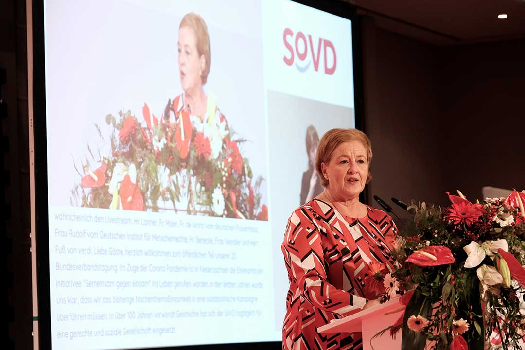 Frau spricht vor einer Leinwand mit SoVD-Logo